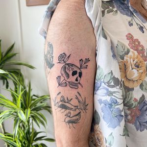 Get a unique patchwork design by Jack Henry Tattoo on your arm with a striking combination of flowers, skulls, and dotwork.