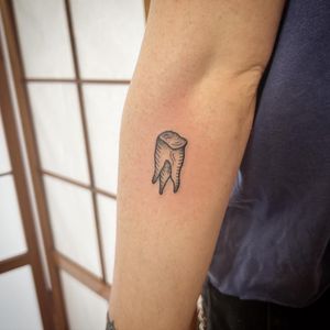 Get a striking tooth design on your forearm by Jack Henry Tattoo, combining blackwork, dotwork, and illustrative styles.