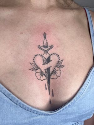 Unique dotwork, fine line, and hand-poke style tattoo by Indigo Forever Tattoos, combining a heart and dagger motif in a stunning design.
