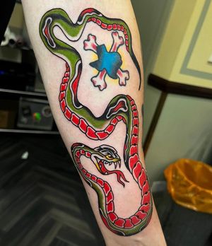 Explore the mesmerizing beauty of a neo traditional snake tattoo on your lower arm by skilled artist Barney Coles.