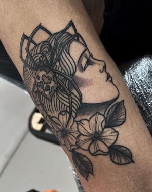 Get mesmerized by Barney Coles' stunning black and gray spider and woman floral design, perfectly placed on your lower arm.