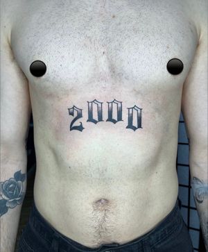 Barney Coles creatively combines numbers in sleek lettering design for a bold and unique stomach tattoo.