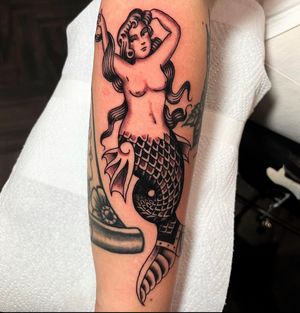 Beautiful mermaid design on forearm by talented artist Barney Coles. A timeless and classic choice for your next tattoo.