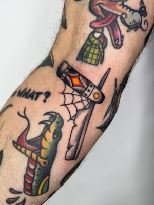 Traditional tattoo featuring a barber theme with a classic knife design, expertly done by artist Claudia Trash.