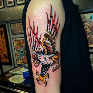 Fly high with this stunning traditional eagle tattoo by Barney Coles, perfect for your upper arm.
