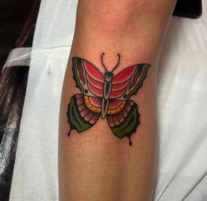 Get inked with a stunning traditional butterfly design on your shin by Barney Coles. Stand out with this beautiful and timeless tattoo!