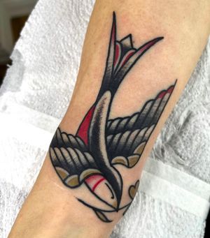 Check out this classic traditional sparrow tattoo by renowned artist Barney Coles, featuring bold lines and vibrant colors.