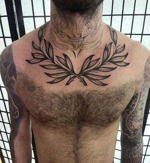 Barney Coles created this illustrative tattoo featuring leafs, a branch, and a laurel wreath, perfect for the chest.