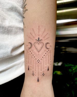 Illuminate your skin with a beautifully intricate ornamental tattoo featuring a crescent moon and heart, crafted by Indigo Forever Tattoos.