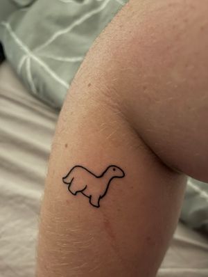 Small dinosaur tattoo on the lower arm