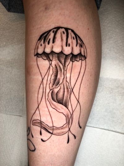 Experience the beauty of the deep sea with this intricate dotwork and fine line jellyfish tattoo by Claudia Whiteheart.