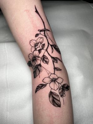Adorn your arm with a stunning floral design by talented artist Claudia Whiteheart, adding a touch of elegance to your body art.