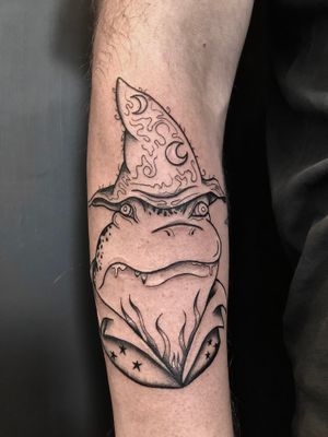 Beautiful fine line tattoo of a whimsical frog wizard, created by Claudia Whiteheart. Perfect for fantasy fans.