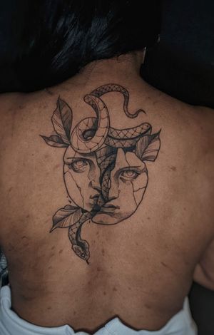 Unique upper back tattoo by Luca Salzano, featuring a striking neo traditional style snake and face motif.