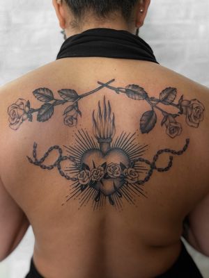 Experience the intricate beauty of a black and gray dotwork tattoo featuring a sacred heart, rose, and chain, expertly created by Jenny Dubet.