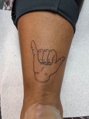 Get inked with Luca Salzano's unique design of a shaka hand sign on your lower leg, showcasing a cool and laid-back style.