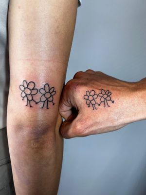 Express your love with this illustrative daisy couple tattoo by Jonathan Glick. Bold and beautiful!