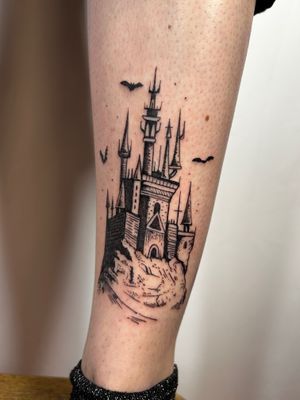 Capture the eerie beauty of a bat flying over a haunting castle, in this stunning fine line illustrative tattoo by Jonathan Glick.