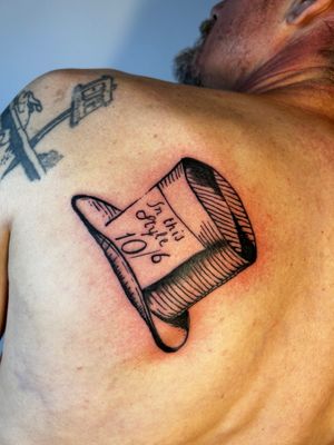 Fine line and small lettering tattoo of a stylish top hat, with illustrative details by the talented artist Jonathan Glick.