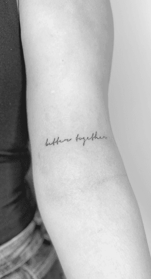 Get a beautiful fine line tattoo with small cursive lettering that says 'better together' by Math.