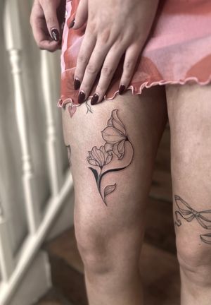 Experience the delicate beauty of a fine line, illustrative flower tattoo expertly crafted by Maddie.