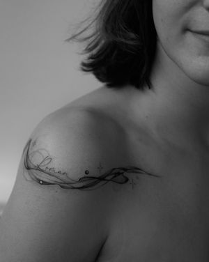 Elegant fine line tattoo with a star and flowing design, personalized with a small lettering name. By artist Victoria.