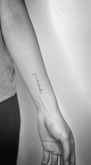 Fine line and small lettering cursive tattoo by Math, expressing gratitude in a stylish way.