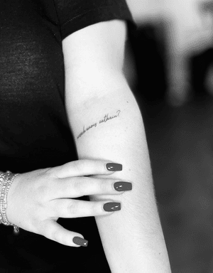 Get a beautifully crafted fine line tattoo with delicate small lettering in cursive by the talented artist Vera.
