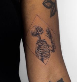 Fine line micro-realism black & gray tattoo by Oscar Jesus featuring a skeleton in prayer within a frame design.
