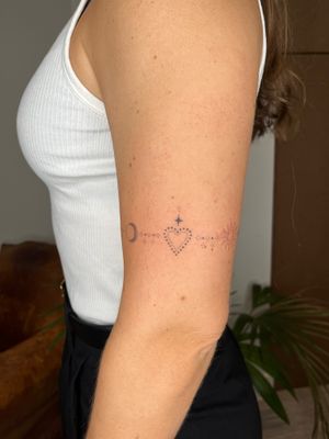 Embrace the harmony of sun, moon, and heart in this delicate ornamental dotwork tattoo by Indigo Forever Tattoos.