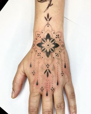 Exquisite hand tattoo featuring a delicate floral motif in ornamental style by Indigo Forever Tattoos.