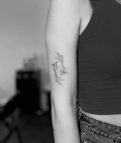 Fine line and illustrative style tattoo featuring a minimalist design of a beta fish, created by the talented artist Vera.