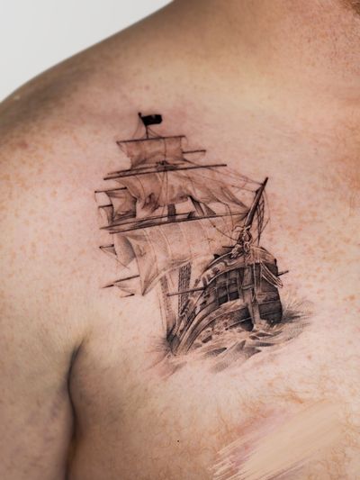Get lost at sea with this fine line black and gray pirate ship tattoo by Oscar Jesus.