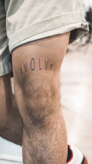 Get inspired to evolve with this stylish small lettering tattoo by the talented artist Seven. Perfect for those looking for a subtle but meaningful ink design.