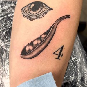 Delicate black and gray tattoo of peas in a pod, expertly done with micro realism technique by the talented artist, Seven.