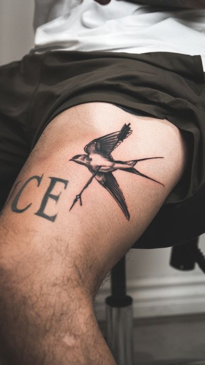 A stunning black and gray illustrative tattoo featuring a swallow and arrow design, expertly crafted by Seven.