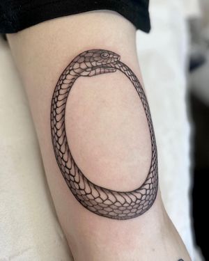 A stunning black and gray tattoo of a snake forming an ouroboros, created by the talented artist Sophie Rose Hunter.