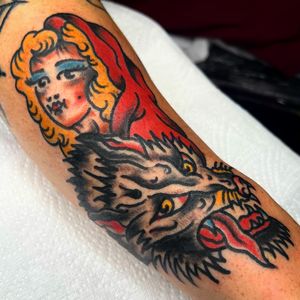 Classic fairy tale tattoo featuring Red Riding Hood and the bad wolf, done by Alessandro Lanzafame.