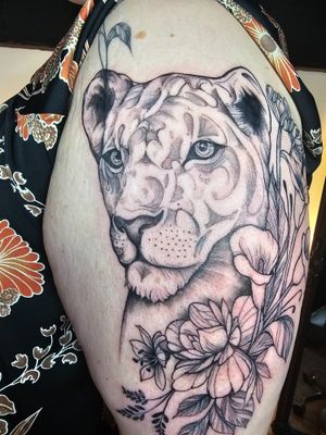 Half sleeve lioness with flowers tattoo
