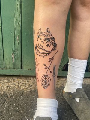 Get inked with a unique traditional tattoo featuring a charming dog design in patchwork style by the talented artist Charlie Macarthur.