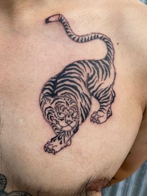 Get fierce with this stunning traditional tiger tattoo by renowned artist Charlie Macarthur. Roar with confidence!