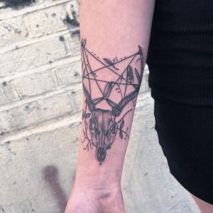 Unique black and gray tattoo by Kiky Flore featuring a combination of a deer and skull motif on the forearm.