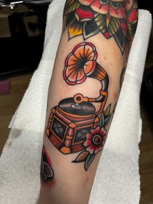 Traditional tattoo featuring a flower, gramophone, disc, and vynil by the talented artist Barney Coles.