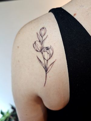 Embrace the delicate beauty of a tulip with this stunning fine line illustrative tattoo by Katia Barria. Perfect for nature lovers!