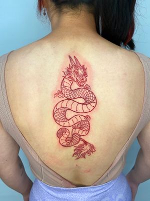Elegant and fierce red ink Japanese dragon tattoo on the upper back done by artist Liam Collins. Perfect for those seeking a bold statement piece.