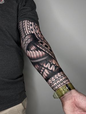Explore the bold patterns and detailed designs of Liam Collins' tribal sleeve tattoo. A stunning display of precision and artistry.