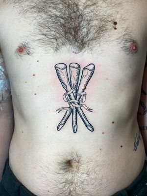 Unique tattoo design featuring a banner and sticks, created by talented artist Liam Collins.