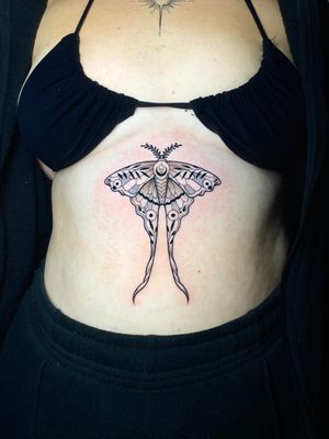 Experience stunning illustrative art with this exquisite moth tattoo by renowned artist Liam Collins. Enhance your beauty with this unique piece of body art.