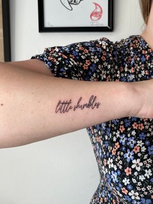 Clean and elegant small lettering tattoo on the lower arm designed by the talented artist Liam Collins.