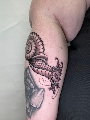 Unique dotwork tattoo featuring a dragon and a snail, expertly done by Liam Collins. A perfect blend of fantasy and nature.
